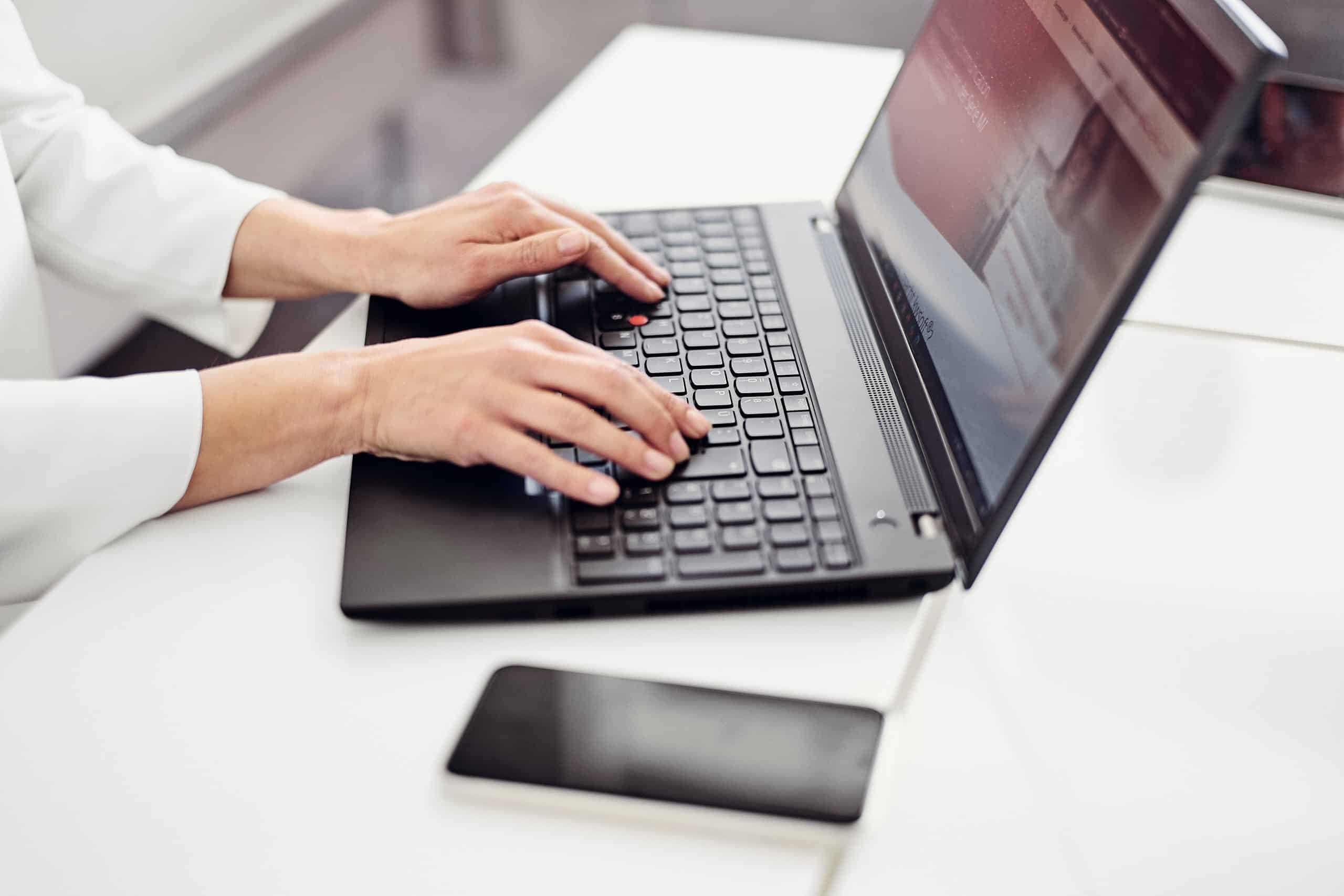 Ktoś siedzi przy laptopie i przegląda stronę internetową kwsoft®.