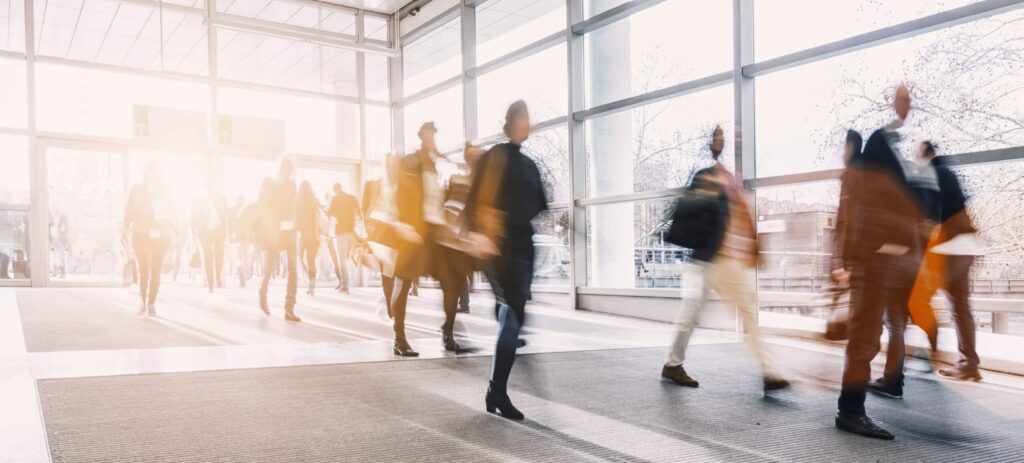 In an entrance hall, a group of people go about their business.